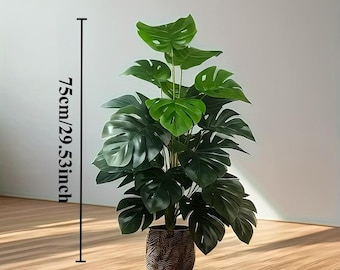 May include: A faux monstera plant with large, dark green, split leaves arranged in a dense cluster. The plant is housed in a textured, dark brown pot. A vertical measurement line indicates a total height of 75cm or 29.53 inches for the plant.