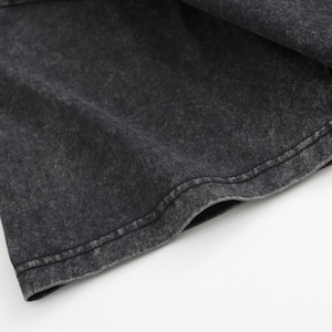May include: A short sleeve of a garment featuring a dark charcoal grey fabric with a mottled, acid-washed texture. The sleeve has a double-stitched hem along the bottom edge, showcasing a consistent, weathered appearance across the material surface.