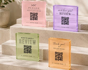 May include: Four square acrylic signs in pastel pink, purple, light green, and orange. Each sign features a printed QR code, the text "SCAN TO LEAVE A REVIEW" or "WE'D LOVE YOUR REVIEW" or "THANK YOU! FOR YOUR REVIEW", and "CUSTOM YOURS" at the bottom.