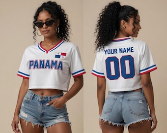 May include: A white cropped V-neck jersey featuring the word PANAMA in blue letters on the front, a small Panama flag patch, and red and blue striped trim on the sleeves and collar. The back displays the text YOUR NAME and the number 00 in blue.