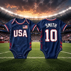Pode incluir: Dois bodies de bebé azul marinho, uma vista frontal e outra traseira, com detalhes vermelhos e brancos. O body da frente tem "USA" em letras brancas e uma bandeira americana. A parte de trás tem "SMITH 10" em branco.
