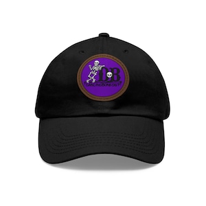 May include: Black baseball cap with a circular patch featuring a dancing skeleton, the initials "DB", and the text "Dancing Bones Su?" in a purple and brown design.