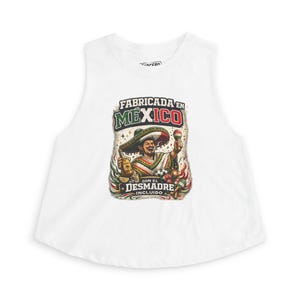 May include: White sleeveless crop top featuring a colorful graphic of a man in a sombrero holding a bottle and maracas. The graphic includes the text "FABRICADA EN MEXICO CON EL DESMADRE INCLUIDO."