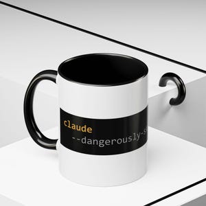 May include: White ceramic mug with a black interior, handle, and a black band. The mug features the name "claude" in gold text above the phrase "--dangerously-s" in white text.