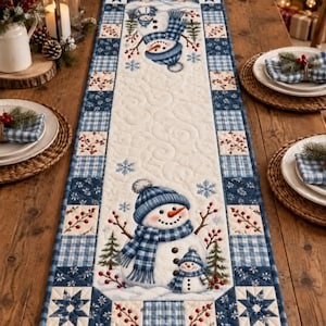 May include: A rectangular quilted table runner featuring a cream-colored center panel with two snowmen wearing blue plaid hats and scarves, surrounded by a border of blue plaid squares, star patterns, and small red berry sprig motifs.