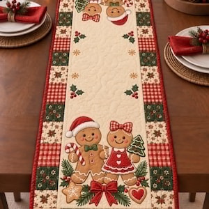 Peut inclure: Un chemin de table matelassé rectangulaire avec un panneau central crème orné de personnages en pain d'épices, de sucres d'orge et de houx. La bordure présente un motif patchwork composé de carreaux rouges et verts et d'étoiles.