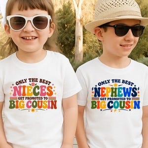 May include: Two white t-shirts featuring colourful retro-style text. The left shirt reads "ONLY THE BEST NIECES GET PROMOTED TO BIG COUSIN" in pink, orange, and green. The right shirt reads "ONLY THE BEST NEPHEWS GET PROMOTED TO BIG COUSIN" in blue and green.