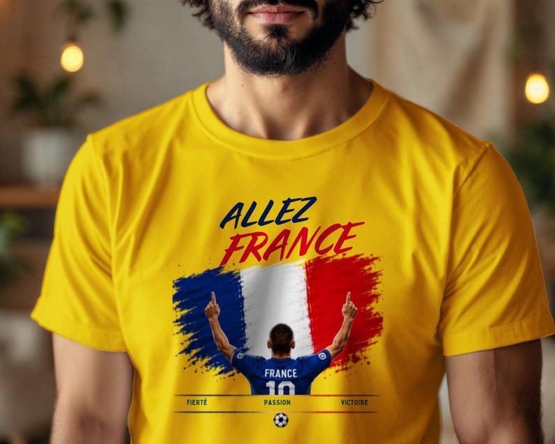 May include: A bright yellow short-sleeved t-shirt featuring the text ALLEZ FRANCE in dark blue and red. Below, a graphic shows a soccer player in a blue jersey with the number 10, set against a French flag background, with FIERT&Eacute;, PASSION, VICTOIRE.