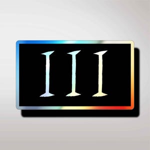 Può includere: Un adesivo rettangolare con uno sfondo nero solido e tre numeri romani I bianchi centrati orizzontalmente. L'adesivo presenta un bordo olografico distintivo che riflette vari colori lungo i suoi bordi esterni.