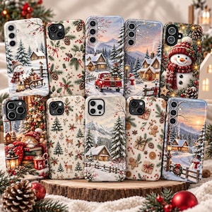 May include: A collection of ten smartphone cases featuring various Christmas-themed illustrations, including snowy landscapes with houses, a red truck, snowmen, a cat resting on books, deer, pine trees, gingerbread cookies, and wrapped gift boxes.