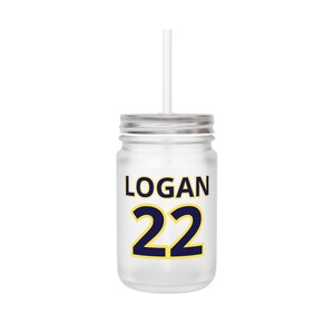 May include: A frosted glass jar with a silver lid and a white straw. The jar features the name "LOGAN" in navy blue letters with a yellow outline, and the number "22" in navy blue with a yellow outline.