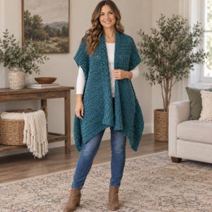 May include: A teal blue sleeveless crochet vest featuring a textured stitch pattern, an open front design, and a relaxed drape. The vest is worn over a plain white long-sleeve shirt paired with blue denim jeans and tan ankle boots.