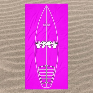 Könnte beinhalten: Ein leuchtend pinkfarbenes, rechteckiges Strandtuch mit einer großen weißen Umrisszeichnung eines Surfbretts. Die Surfbrettgrafik zeigt eine Mittellinie, ein kleines Kronensymbol, ein Paar Hände, ein Paar Füße und ein Traktionspad am unteren Ende.