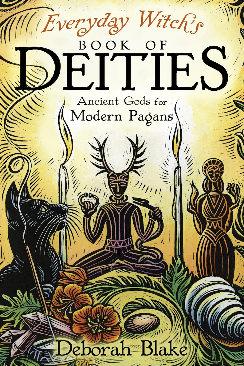 Op de afbeelding: Boekomslag voor "Everyday Witch's Book of Deities" van Deborah Blake. De illustratie toont een zwarte kat, figuren, kaarsen en bloemelementen in een warm kleurenpalet. De titel van het boek en de naam van de auteur zijn prominent aanwezig.