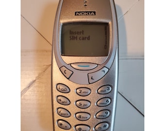 Test starego srebrnego telefonu komórkowego Nokia 3390b z ładowarką włączającą się