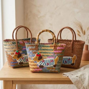 May include: Three woven tote bags with two handles each. The bags feature a multicolored diagonal weave pattern. Two of the bags display a textured applique of a brown dog wearing a blue and white striped shirt and a red hat.
