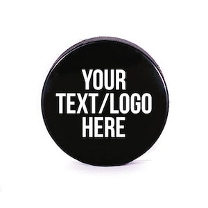 May include: Black hockey puck with white text that says "YOUR TEXT/LOGO HERE".