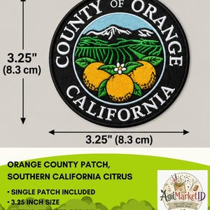 May include: A circular embroidered patch featuring the text COUNTY OF ORANGE CALIFORNIA. The design displays three orange citrus fruits with green leaves and a white blossom, set against a landscape of green fields and mountains. It measures 3.25 inches.