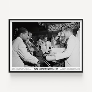 May include: Black and white framed print featuring the Duke Ellington Orchestra. The image shows musicians playing instruments, including a trombone, trumpet, and piano. The text at the bottom identifies the orchestra members and their instruments.