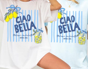 Könnte beinhalten: Ein weißes T-Shirt mit blauem vertikalem Streifenmuster, gelben Zitronen, einer blauen Schleife und einem Einmachglas-Motiv. Der Text Ciao Bella, Melissa's bachelorette und Naples 2026 steht in blauer Schrift in der Mitte des Kleidungsstücks.