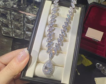 Glittrande päronformade kristallörhängen och halsbandset med silverfärgade strass-smycken för brud och afton