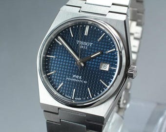 Relógio automático Tissot PRX Powermatic 80 com mostrador azul e pulseira de aço inoxidável.