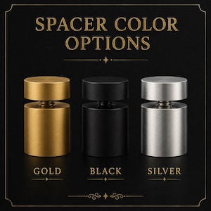 May include: Three cylindrical metal spacers displayed in a row with the text SPACER COLOR OPTIONS at the top. The spacers are available in gold, black, and silver finishes, each featuring a flat top cap and a threaded screw mechanism in the centre.