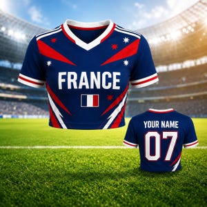 May include: A navy blue athletic jersey with the word "FRANCE" in white block letters. The jersey has red and white accents, a V-neck, and a small French flag. A second jersey shows "YOUR NAME" and the number "07".