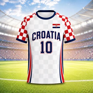 Może przedstawiać: Biała koszulka piłkarska z napisem "CROATIA" i numerem "10" w kolorze granatowym. Koszulka ma czerwono-białe wzory w kratkę na ramionach i rękawach, z czerwonymi i niebieskimi paskami po bokach. Na piersi widnieje flaga Chorwacji.