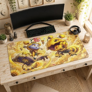May include: A rectangular desk mat featuring a vibrant yellow and gold illustration of a whimsical creature with large eyes reading a purple book, alongside a fuzzy bee-like monster, surrounded by sunflowers, honeycombs, and floating pollen particles.