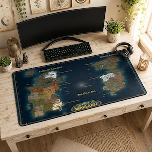 May include: A rectangular desk mat featuring a detailed map of the World of Warcraft game world, including the Lands of Kalimdor and Eastern Kingdoms, with the World of Warcraft logo printed in gold text at the bottom center on a dark blue background.