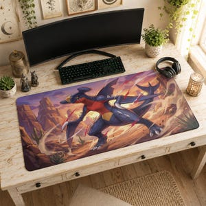 Puede incluir: Una alfombrilla de escritorio rectangular con una colorida ilustración de la criatura Garchomp azul oscuro y roja en un paisaje desértico con cactus y formaciones rocosas, colocada sobre un escritorio de madera bajo un monitor de ordenador.