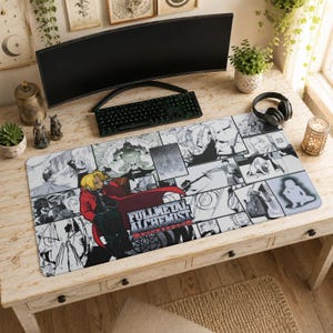 Könnte beinhalten: Eine rechteckige Schreibtischunterlage mit einer schwarz-weißen Manga-Collage aus Fullmetal Alchemist Brotherhood, einer zentralen Figur in einem roten Mantel und dem Serientitel in fetter, dunkler Schrift im unteren Bereich.