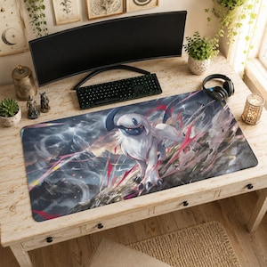 Könnte beinhalten: Eine rechteckige Schreibtischunterlage mit einer detaillierten Illustration der weiß-blauen Kreatur Absol, die auf einer felsigen Klippe steht. Der Hintergrund zeigt eine stürmische Berglandschaft mit wirbelnden Wolken.