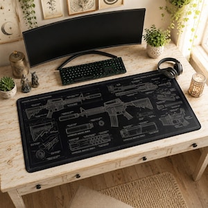 May include: A large black rectangular desk mat featuring a white technical blueprint design of a rifle and its components, including suppressor analysis panels, with detailed mechanical diagrams and labels printed across the surface.