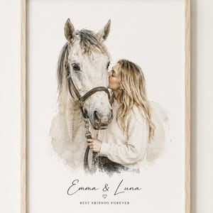 Könnte beinhalten: Ein gerahmter Druck im Aquarellstil zeigt eine Person mit langem blondem Haar, die ein helles Pferd küsst. Das Pferd trägt einen dunklen Lederzaum. Unter der Illustration steht der Text Emma & Luna, ein kleines Herz und BEST FRIENDS FOREVER.