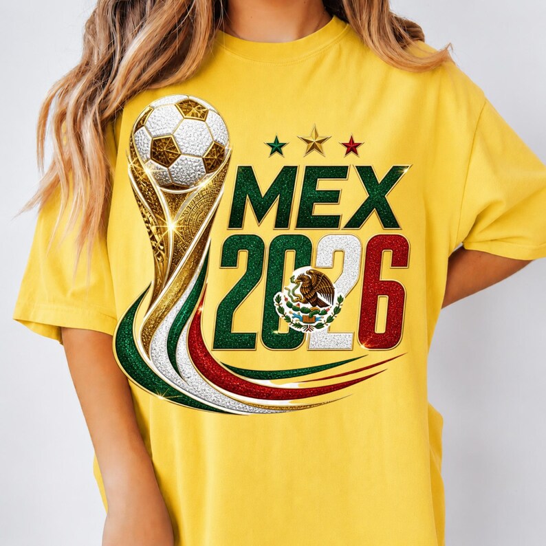 May include: A bright yellow t-shirt featuring a graphic of a soccer ball atop a gold trophy. The text reads MEX 2026, with the numbers colored in green, white, and red. The Mexican coat of arms is centered within the zero, and three stars appear above.