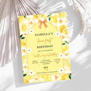 Könnte beinhalten: Eine Einladung zum Geburtstag mit Zitronen-Thema mit dem Text "Isabella's lemon first birthday". Die Einladung zeigt einen gelben Vichy-Hintergrund, Zitronenillustrationen und florale Akzente. Die Einladung enthält Veranstaltungsdetails.