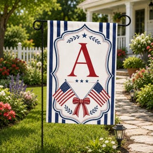May include: A rectangular garden flag featuring a white center with a large red letter A, three small blue stars, and two crossed American flags tied with a red bow. The border has a blue and white vertical stripe pattern with decorative flourishes.