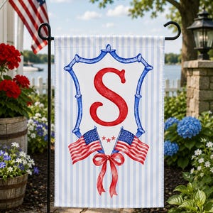 May include: A rectangular garden flag featuring a light blue and white vertical striped background. Centered is a blue bamboo-style crest frame enclosing a large red letter S. Below the letter are two crossed American flags and a red ribbon.