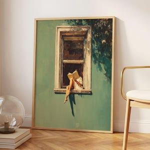 May include: A framed wall art print featuring a painting of a person sitting on a window ledge reading an open book. The scene is set against a solid sage green wall with a rectangular window frame and dark shadows cast by foliage above.