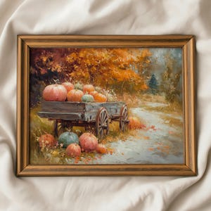 May include: A framed oil painting depicting a rustic wooden cart filled with orange and green pumpkins, positioned on a path surrounded by autumn foliage in shades of gold and brown, with additional pumpkins resting on the ground nearby.