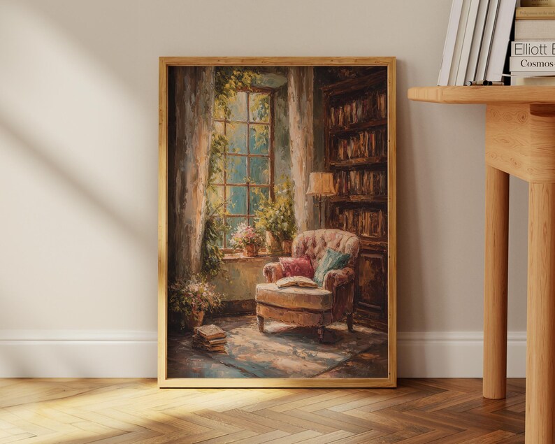 May include: A framed painting depicts a cozy reading nook. A tufted armchair with pillows sits near a window with sunlight streaming through. A bookshelf and a stack of books add to the inviting atmosphere. The artwork is in warm, earthy tones.