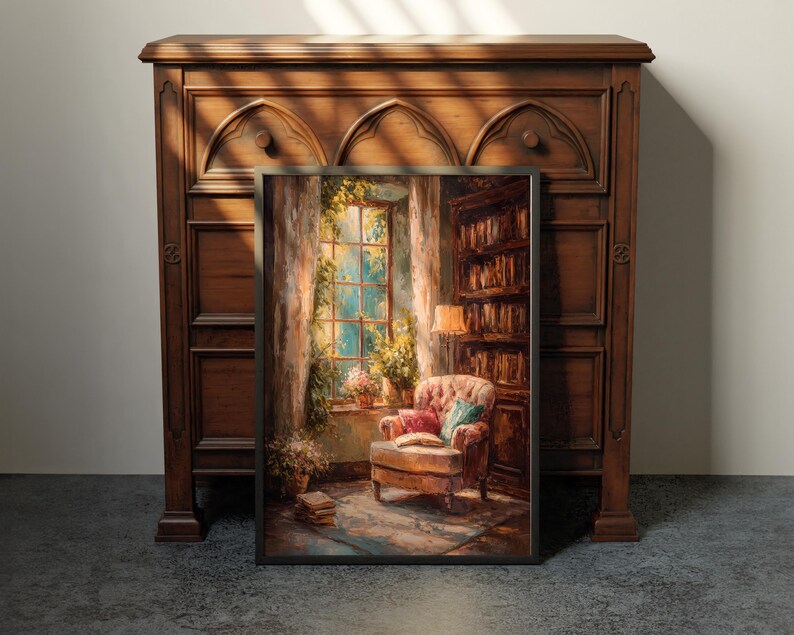 May include: A framed painting depicts a cozy reading nook with a window, armchair, and bookshelf. The artwork features warm tones, with a focus on the armchair, open book, and soft lighting. The painting is set against a dark wooden cabinet.