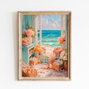 May include: An oil painting in a light wood frame depicting an open window overlooking a turquoise ocean. The scene features wooden crates filled with white seashells, orange coral, and vases of pink and white hydrangea flowers on a sandy floor.