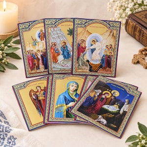 May include: A collection of six rectangular religious icons featuring vibrant illustrations of biblical scenes and figures, each framed with a decorative blue and gold border. The icons depict various events including the Nativity and the Resurrection.