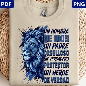 May include: A beige crewneck t-shirt featuring a blue graphic of a lion's head on the left and the text UN HOMBRE DE DIOS UN PADRE ORGULLOSO UN VERDADERO PROTECTOR UN HÉROE DE VERDAD in blue stacked lettering on the right side of the design.