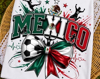 May include: A white t-shirt featuring a graphic print with the word MEXICO in large block letters. The design includes silhouettes of soccer players, a soccer ball, the Mexican coat of arms, and a large bow colored in green, white, and red.