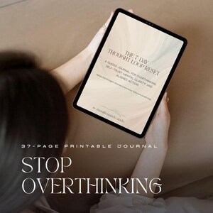 Puede incluir: Una tableta que muestra un diario imprimible de 37 páginas titulado The 7-Day Thought Loop Reset, un diario guiado para la sobrepensamiento, la autoconfianza, la claridad mental y la acción alineada. La pantalla tiene un fondo de mármol beige y el texto Stop Overthinking.