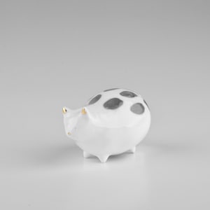 Porcelain white cat figurine with gold/black decoration.